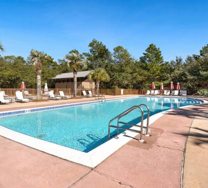 Sparkling pool surrounded by palm trees and lounge chairs where you can soak up the sun and unwind in paradise.