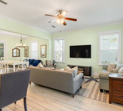 Relax in your spacious open-concept living area with comfortable seating, modern TV, and charming coastal touches throughout.