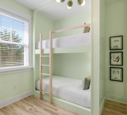 Your cozy bunk room features built-in beds with soft green walls, creating a peaceful retreat for restful nights.