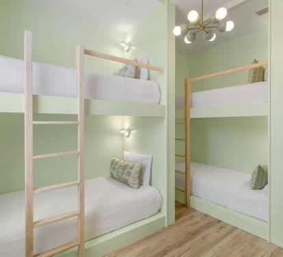 Rest easy in your stylish bunk bed sanctuary with soft green walls and modern lighting creating a peaceful retreat.