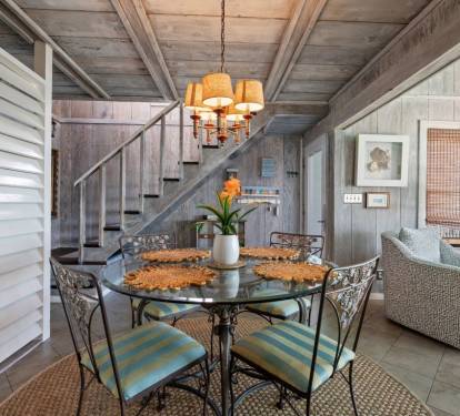 Cozy dining nook with warm lighting where you'll enjoy meals beneath rustic beamed ceilings and coastal-inspired décor.