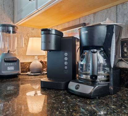 Wake up to fresh coffee from your well-equipped kitchen featuring a premium coffee maker, grinder, and blender for delicious mornings.
