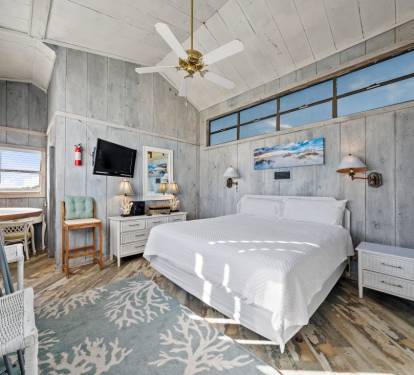 Drift off in this coastal bedroom where weathered wood meets ocean-inspired decor, your morning light streaming through oversized windows.