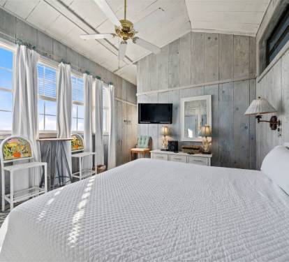 Rest peacefully in your charming beach cottage bedroom, where weathered wood walls and ocean breezes create the perfect coastal retreat.