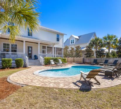 Beautiful coastal home with private pool surrounded by swaying palms and comfortable loungers for the perfect Florida getaway.