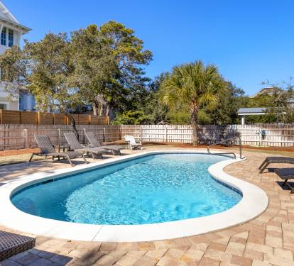 Dive into your private oasis featuring crystal-clear waters surrounded by comfortable loungers on elegant stone decking.
