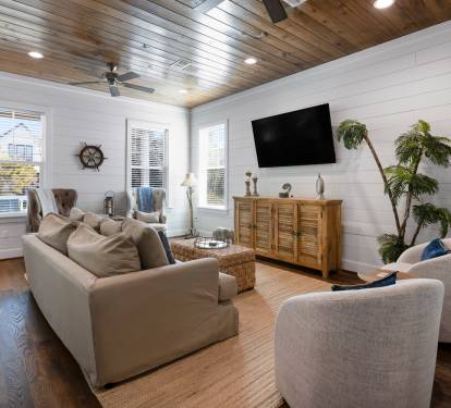 Unwind in your coastal-inspired living space with soaring wood ceilings, plush seating, and nautical touches that create the perfect retreat.