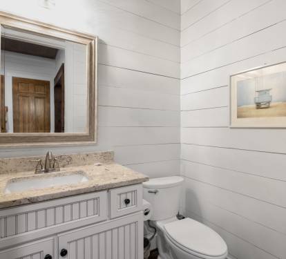 You'll love this bright bathroom with its coastal charm and granite counters for your morning routine.