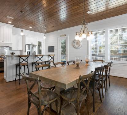 Gather around this stunning farmhouse dining table where your family meals become cherished memories beneath the warm wood ceiling.