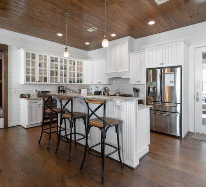 Your dream kitchen awaits with gleaming granite countertops, premium stainless appliances, and charming rustic wood ceiling beams overhead.