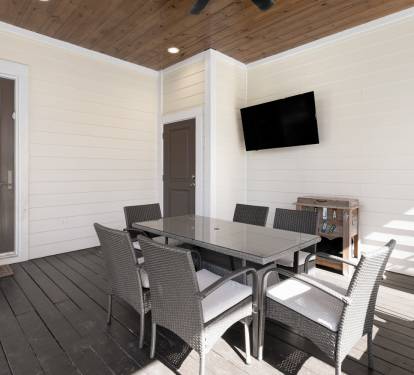 Your private covered patio offers comfortable dining with modern furnishings and entertainment, perfect for enjoying meals outdoors year-round.