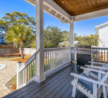 Your covered deck offers a perfect spot to grill and relax, overlooking the sparkling pool and tropical landscaping below.