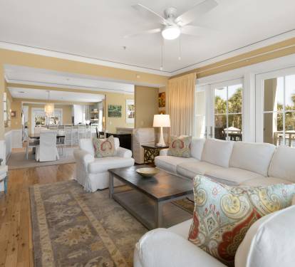 Unwind in your spacious living room with plush seating and tropical views through French doors leading to your private balcony.