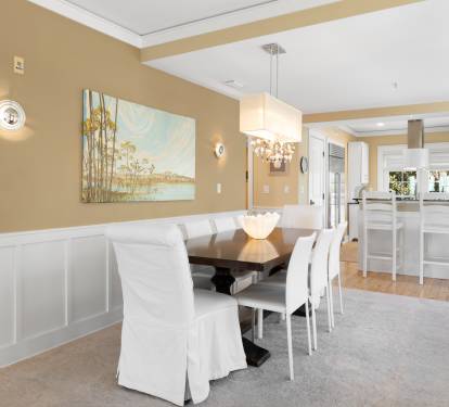 Gather around your elegant dining table for memorable meals in this sophisticated space with beautiful artwork and crystal chandelier.