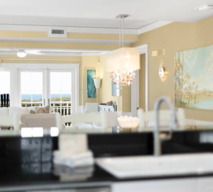 Your spacious kitchen opens to an elegant living area with stunning ocean views through floor-to-ceiling windows.