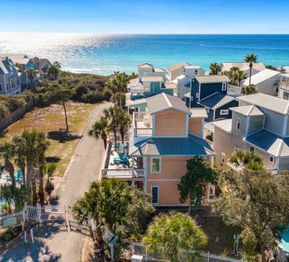 Coastal vacation rental community featuring colorful beach houses, swimming pools, and pristine turquoise waters just steps away.