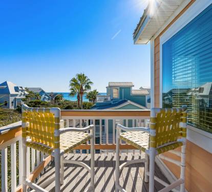 Bright yellow chairs await on your private balcony, perfect for morning coffee while soaking up coastal views and gentle gulf breezes.