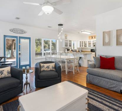 Relax in this bright, coastal-inspired living space where comfortable seating and an open layout create perfect gathering spots for your group.