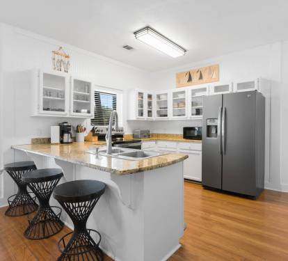 Your bright, fully-equipped kitchen features granite countertops, stainless steel appliances, and a breakfast bar perfect for morning coffee.