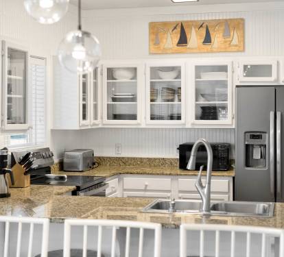 Your fully equipped kitchen features granite counters, modern appliances, and coastal charm - perfect for preparing meals during your getaway.