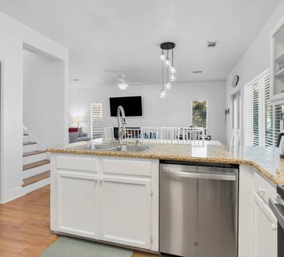 Your open kitchen flows seamlessly into the bright living space, featuring granite counters and stainless appliances perfect for preparing vacation meals.
