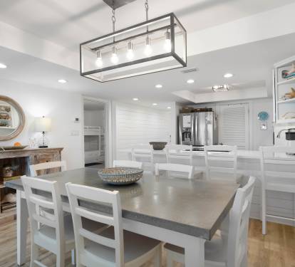 Gather with loved ones in your open-concept kitchen and dining area, where bright white finishes and elegant lighting create the perfect backdrop for memorable meals.