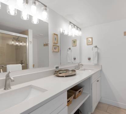 Your spacious bathroom features dual vanities with elegant white countertops, perfect for getting ready together each morning.