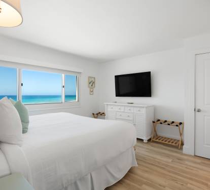 Wake up to breathtaking gulf views from your serene bedroom sanctuary, where white linens and coastal breezes create the perfect retreat.