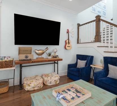 Relax in your charming living room where coastal blues meet warm wood tones, complete with entertainment and cozy seating.