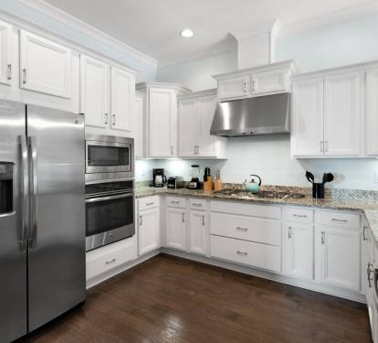 Your fully-equipped kitchen features gleaming granite counters, stainless steel appliances, and pristine white cabinetry—perfect for preparing memorable meals during your stay.
