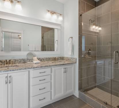 Your spacious bathroom features elegant granite countertops, bright vanity lighting, and a luxurious glass-enclosed shower for ultimate relaxation.