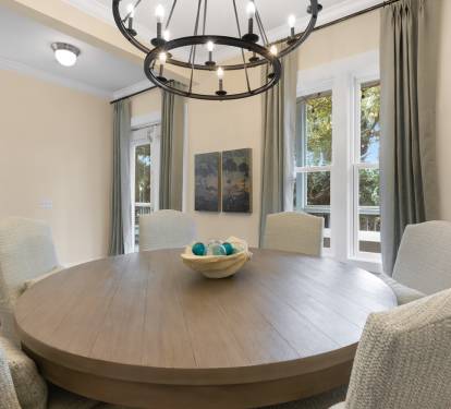 Gather around your elegant dining table for memorable meals, illuminated by stylish chandelier lighting and surrounded by comfortable seating.