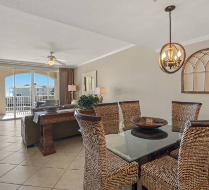 Gather around the elegant dining table with wicker chairs, where natural light floods in through arched windows overlooking the neighborhood.