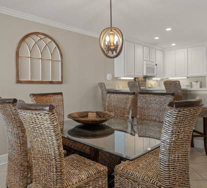 Dining space features wicker chairs around a glass table, perfect for memorable meals together.