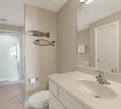 Step into the serene Primary bathroom with coastal touches and a refreshing shower to wash away the day's adventures.