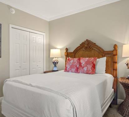 Sink into crisp white linens and tropical comfort in the peaceful bedroom retreat, complete with charming wicker touches and warm coastal lighting.