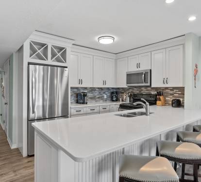 Kitchen with granite countertops, modern cabinetry, full-size refrigerator, oven, microwave, and dishwasher