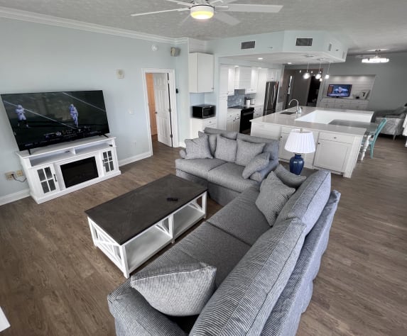 New living room furniture &amp; 65" TV on fireplace overlooking the Gulf