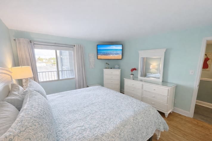 Spacious primary bedroom with KING BED and soft coastal tones and decor. 