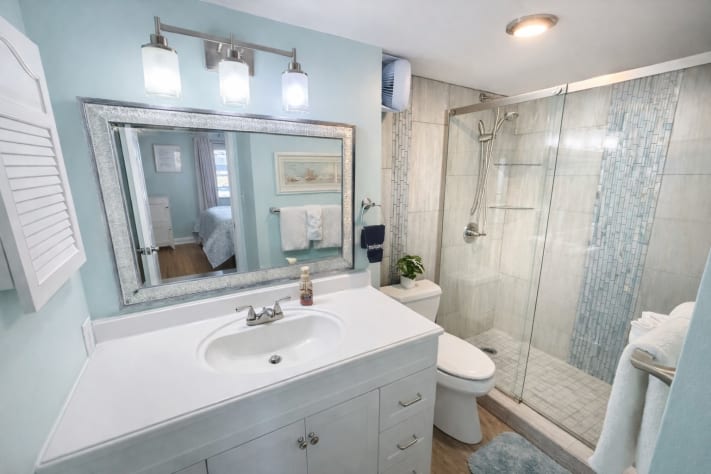 Updated primary bathroom with spacious walk-in shower with coastal finishes.