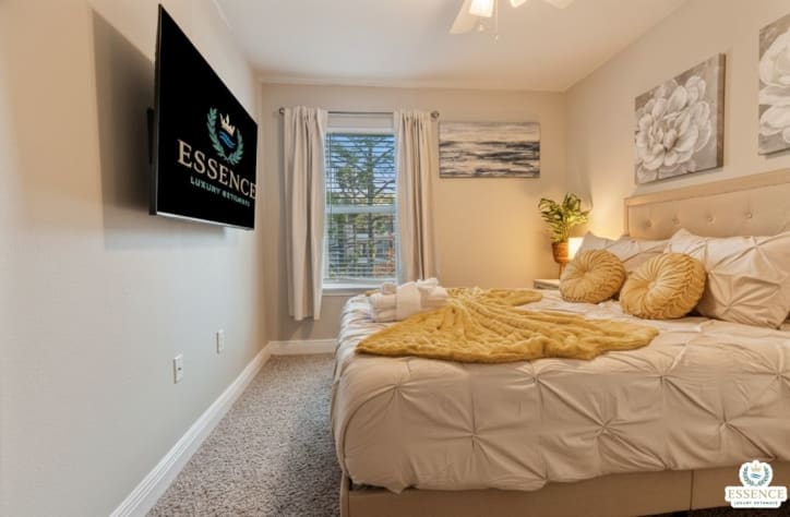 Cozy, beautifully styled bedroom with a plush bed, soft linens, and calming d&eacute;cor. Enjoy natural light, a wall-mounted TV, and a peaceful atmosphere perfect for relaxing and recharging after a fun day out.