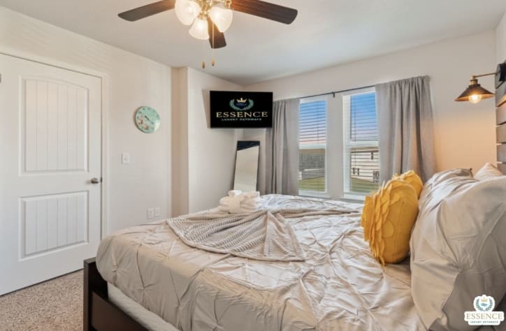 Relax in this serene bedroom featuring a plush bed, stylish wood headboard, smart TV, and soft natural light. Thoughtfully designed for comfort and rest, it&rsquo;s the perfect retreat after a day of adventure or work.