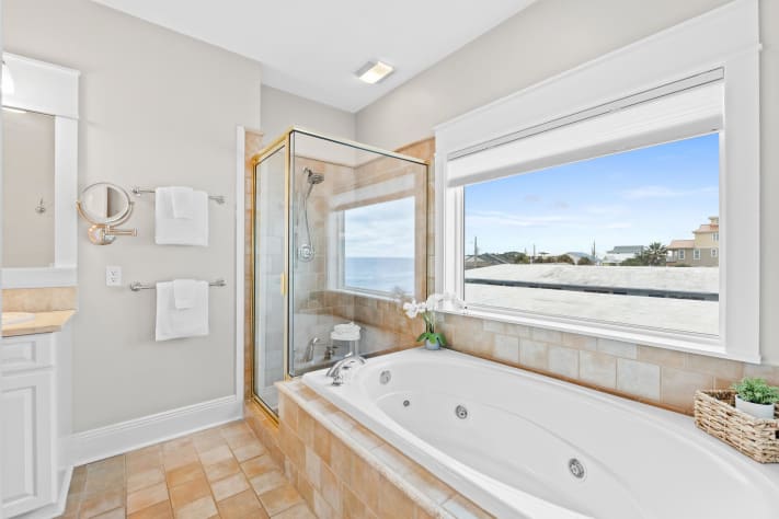 Indulge in spa-like relaxation in this ensuite with a jetted tub, walk-in shower, and water views. After a day at the beach, nothing compares to unwinding in your private retreat with luxury finishes.