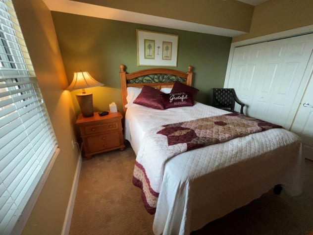 Queen-sized bedroom with soft carpet and ample storage space to store your belongings.