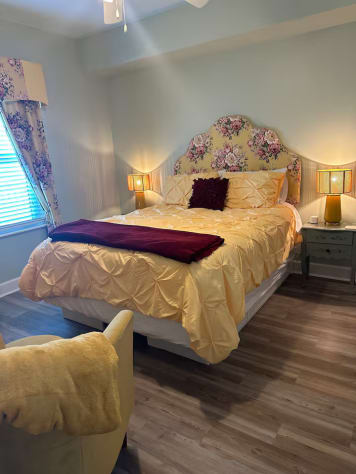 Queen pedestal bed with mini storage drawers beneath. Great sitting area, wall TV, and extras