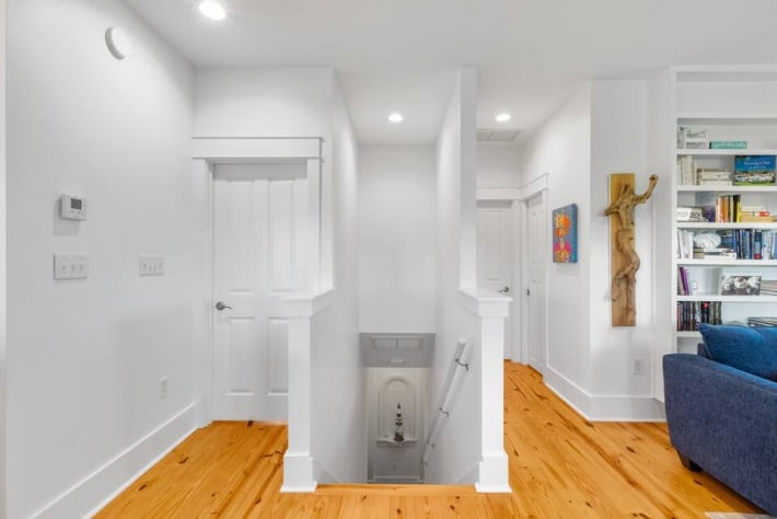 Staircase from living area and bedrooms to entry to front door.