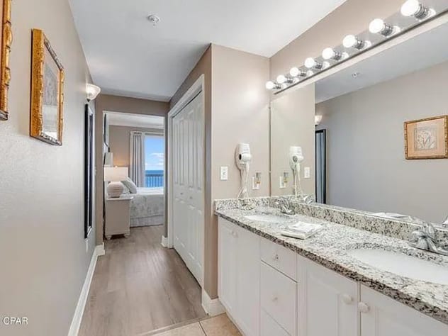 Elegant master bathroom with double sinks, granite counters, and coastal flair
