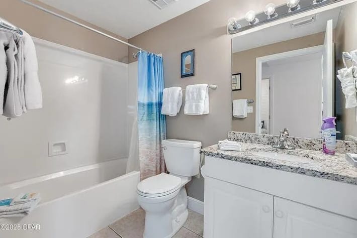 Bright guest bathroom with granite vanity&mdash;clean, coastal, and thoughtfully stocked
