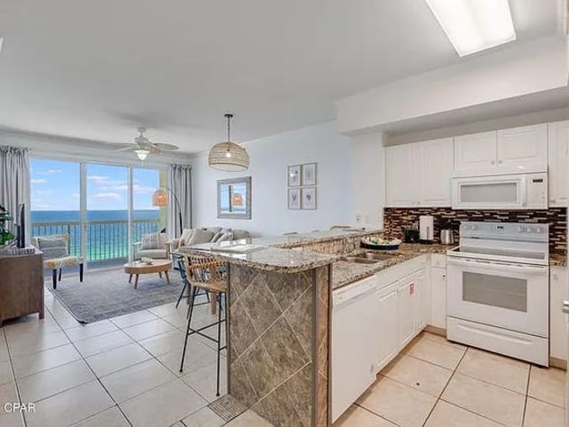 Bright coastal kitchen with bar seating and stunning Gulf views