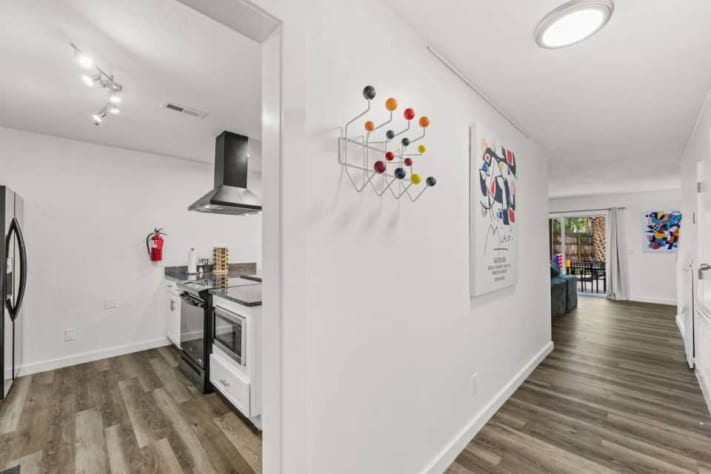 Step into Unit B, the left-hand home when facing the duplex. Its ground floor connects the kitchen, dining area, and smart-TV lounge, with a half bathroom and laundry for convenience. All three bedrooms and both full bathrooms are upstairs